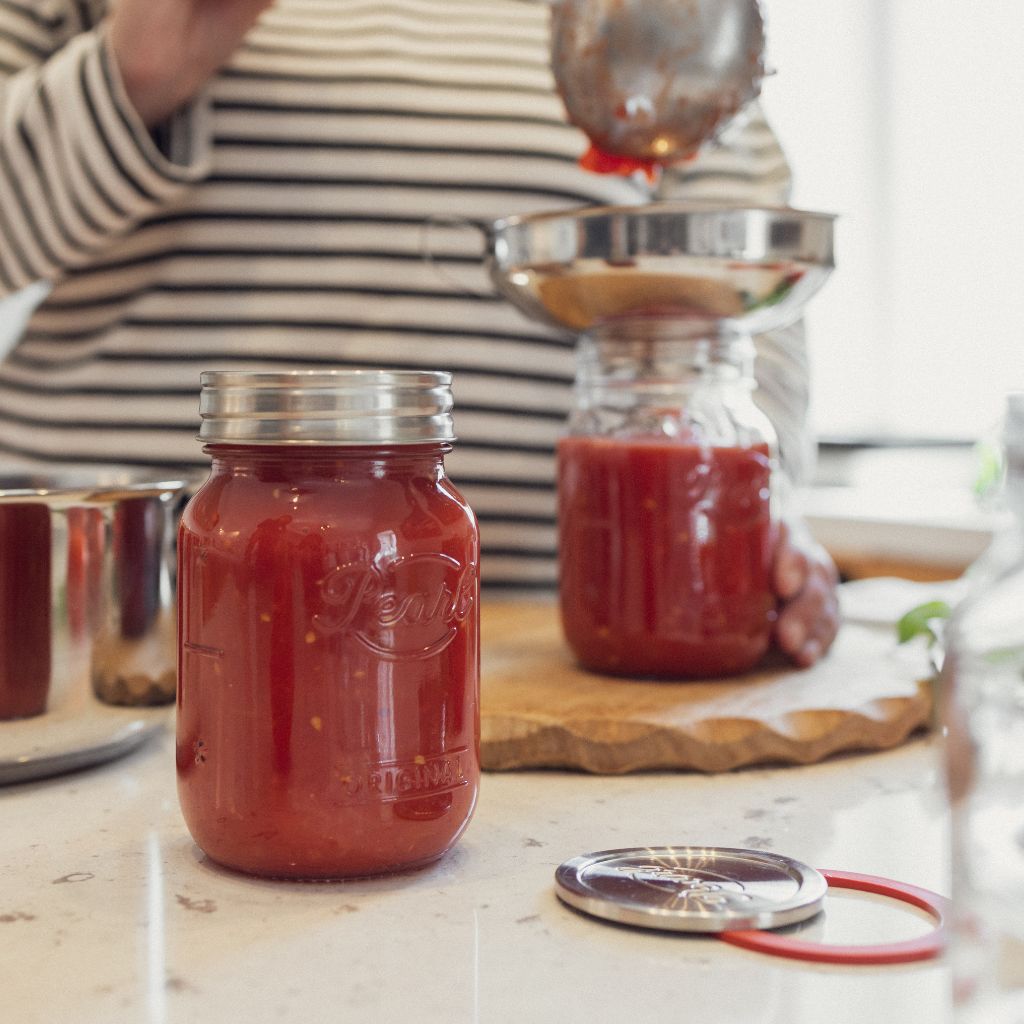 Filling Original Luna Preserving Jars with tomato sauce using funnel